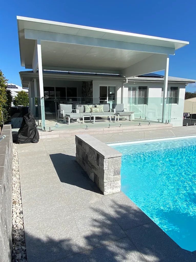 a house backyard with a large pool and a porch — PK4 Projects in Port Macquarie, NSW