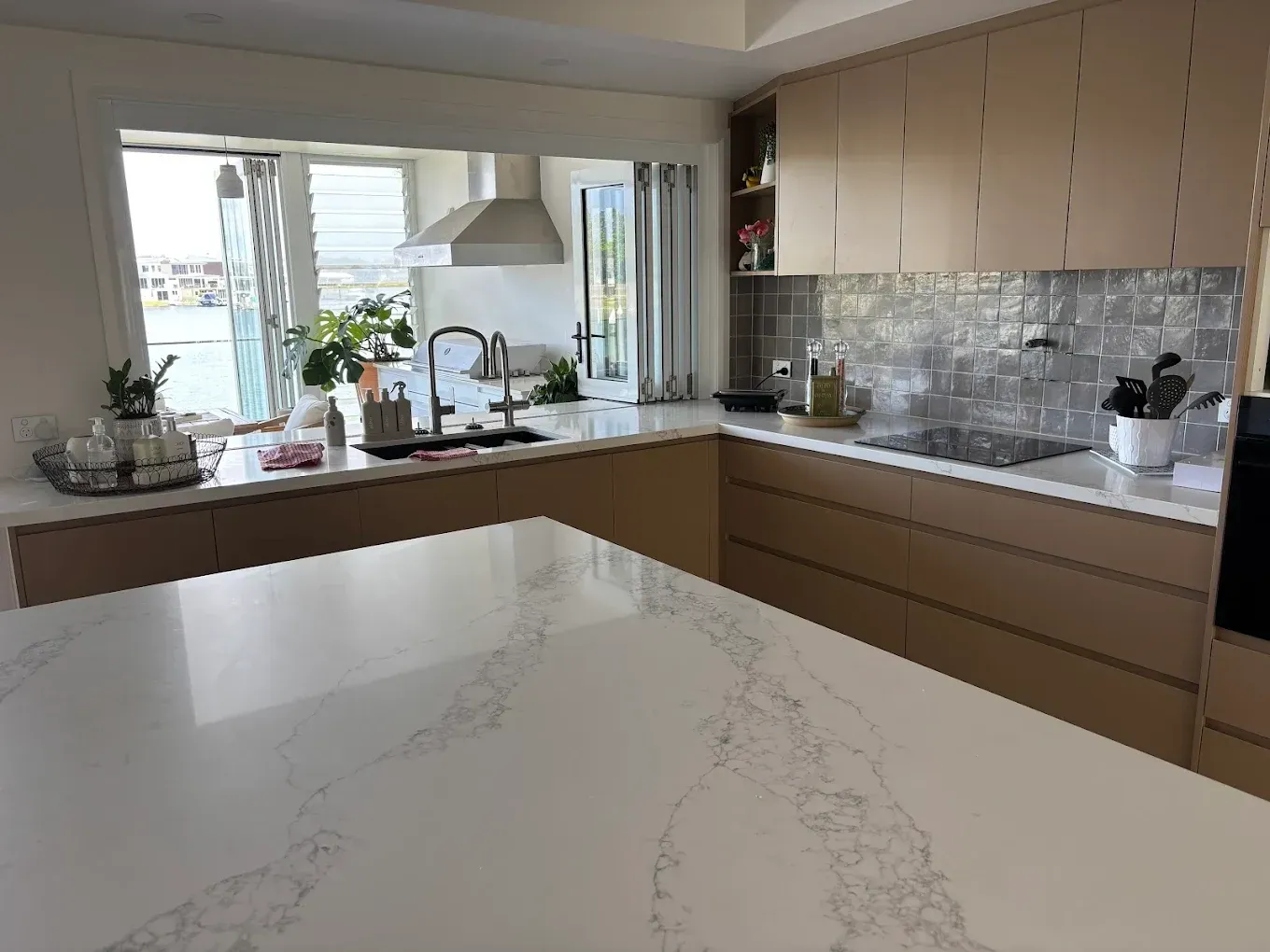 Modern kitchen with light wood cabinets, white countertops, and a window with a view — PK4 Projects in Port Macquarie, NSW