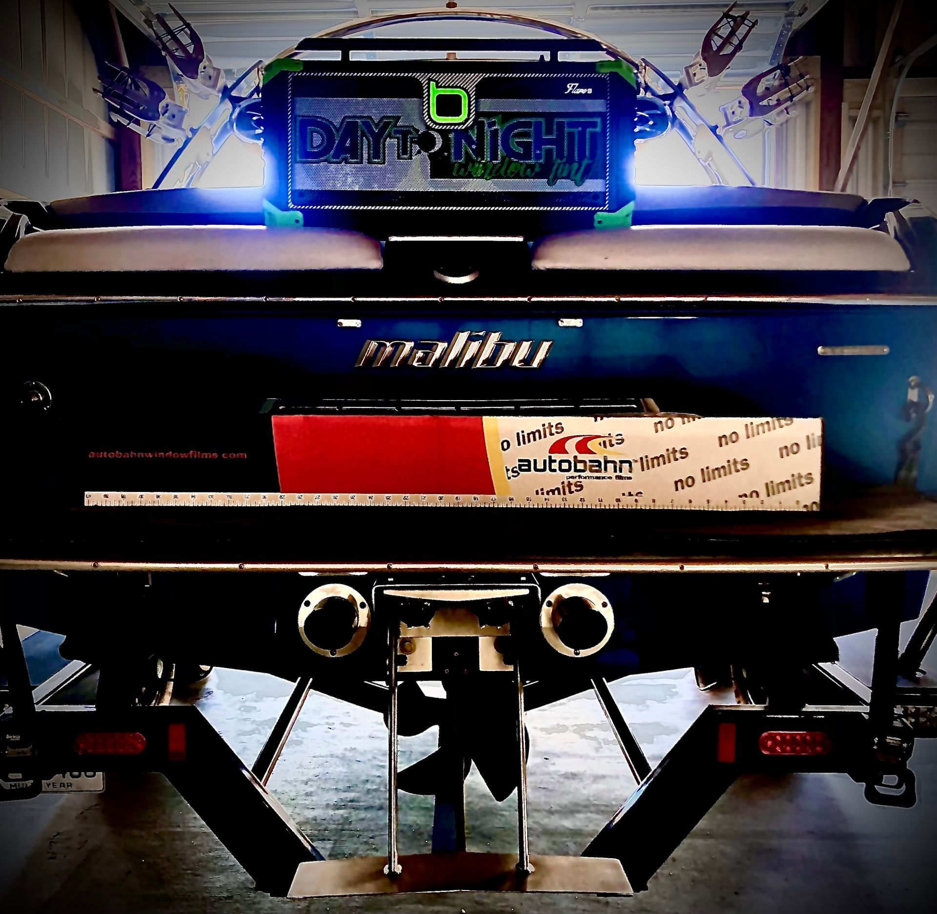 Rear view of a dark blue Malibu boat, with a