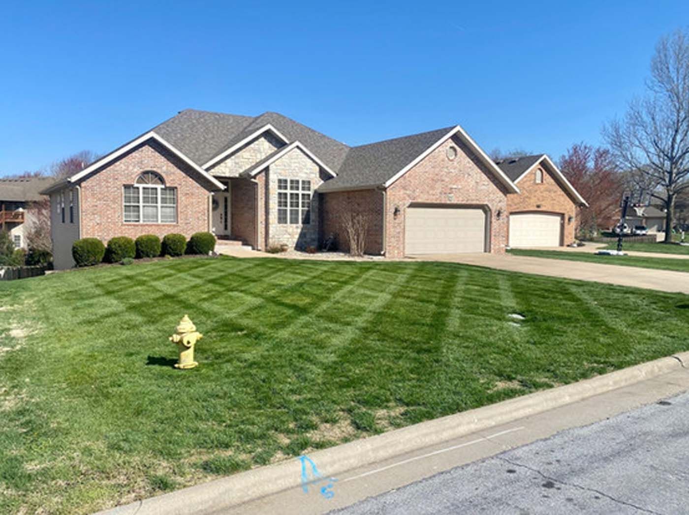 A large brick house with a fire hydrant in front of it.
