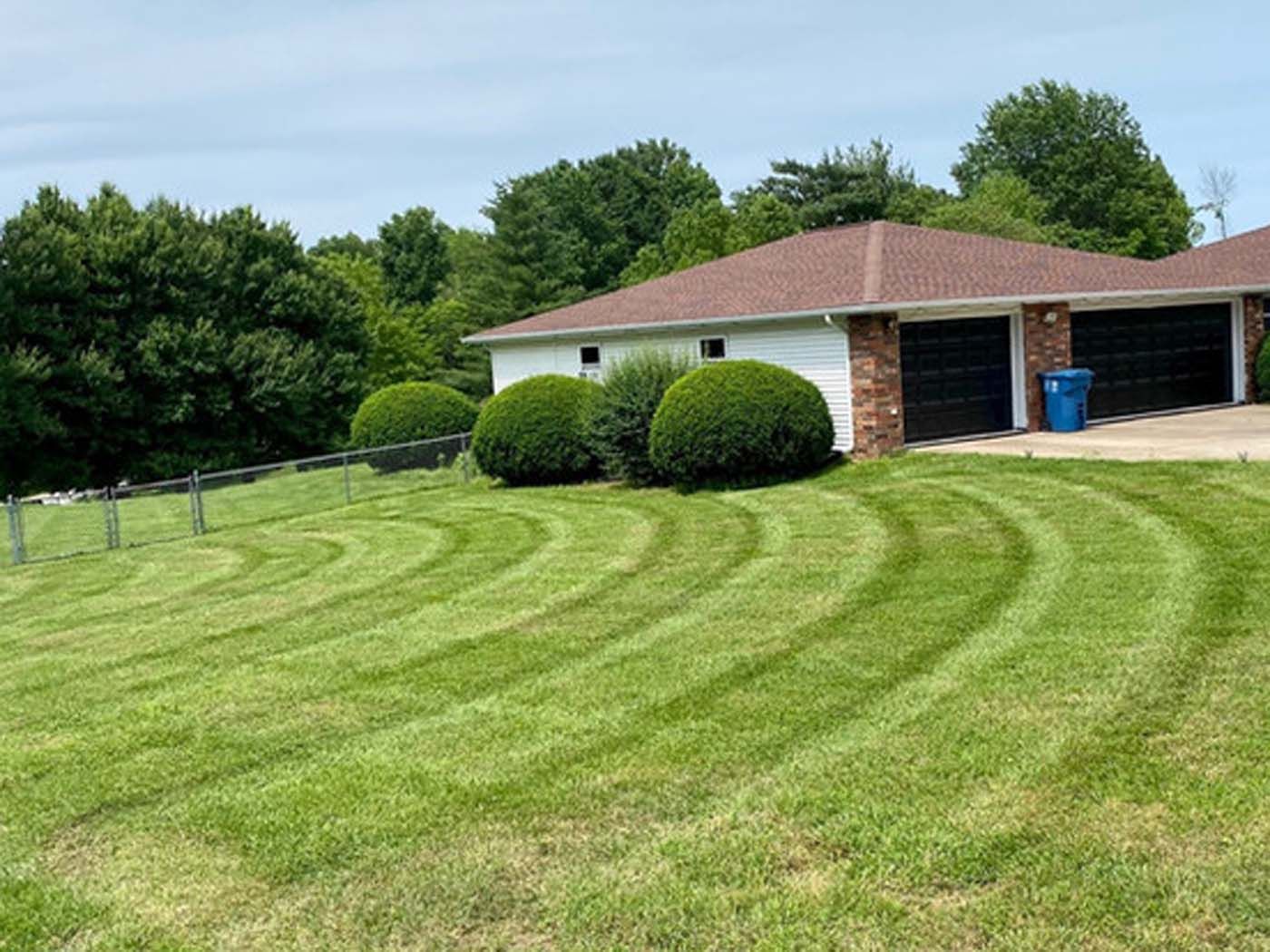 A house with a lush green lawn in front of it.