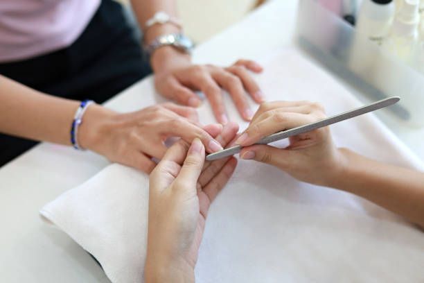 A woman is getting her nails done at a nail salon.