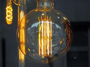 A close up of a light bulb hanging from a ceiling.