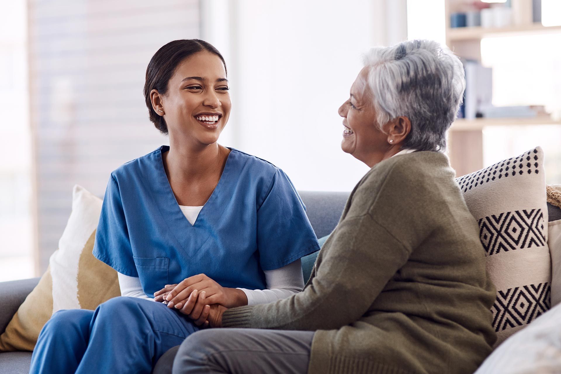 A senior woman and a caregiver are chatting, showcasing an in-home senior healthcare service. A senior woman and a caregiver are chatting, showcasing an in-home senior healthcare service.