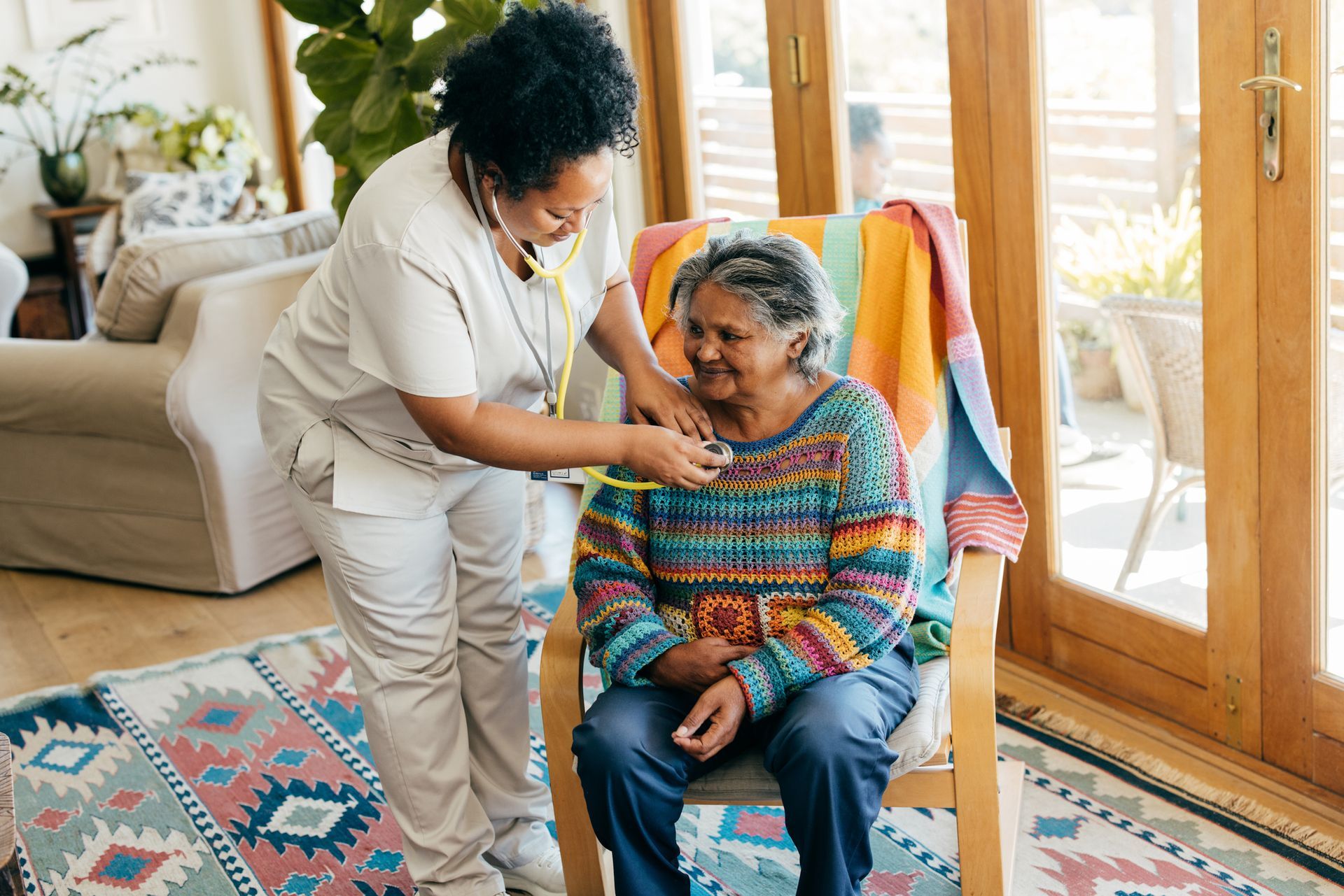 Nurse from in-home health care agency checking elderly woman’s heartbeat at home. Nurse from in-home health care agency checking elderly woman’s heartbeat at home.