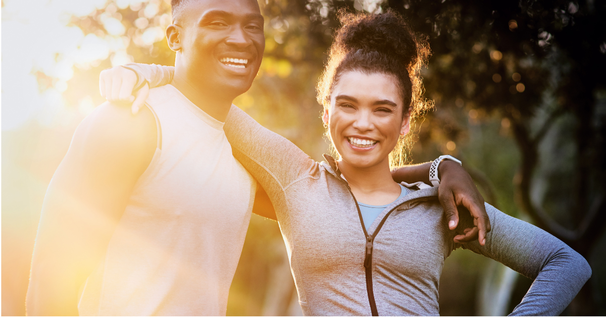 Smiling couple outdoors after a wellness session, representing restored energy and vitality achieved
