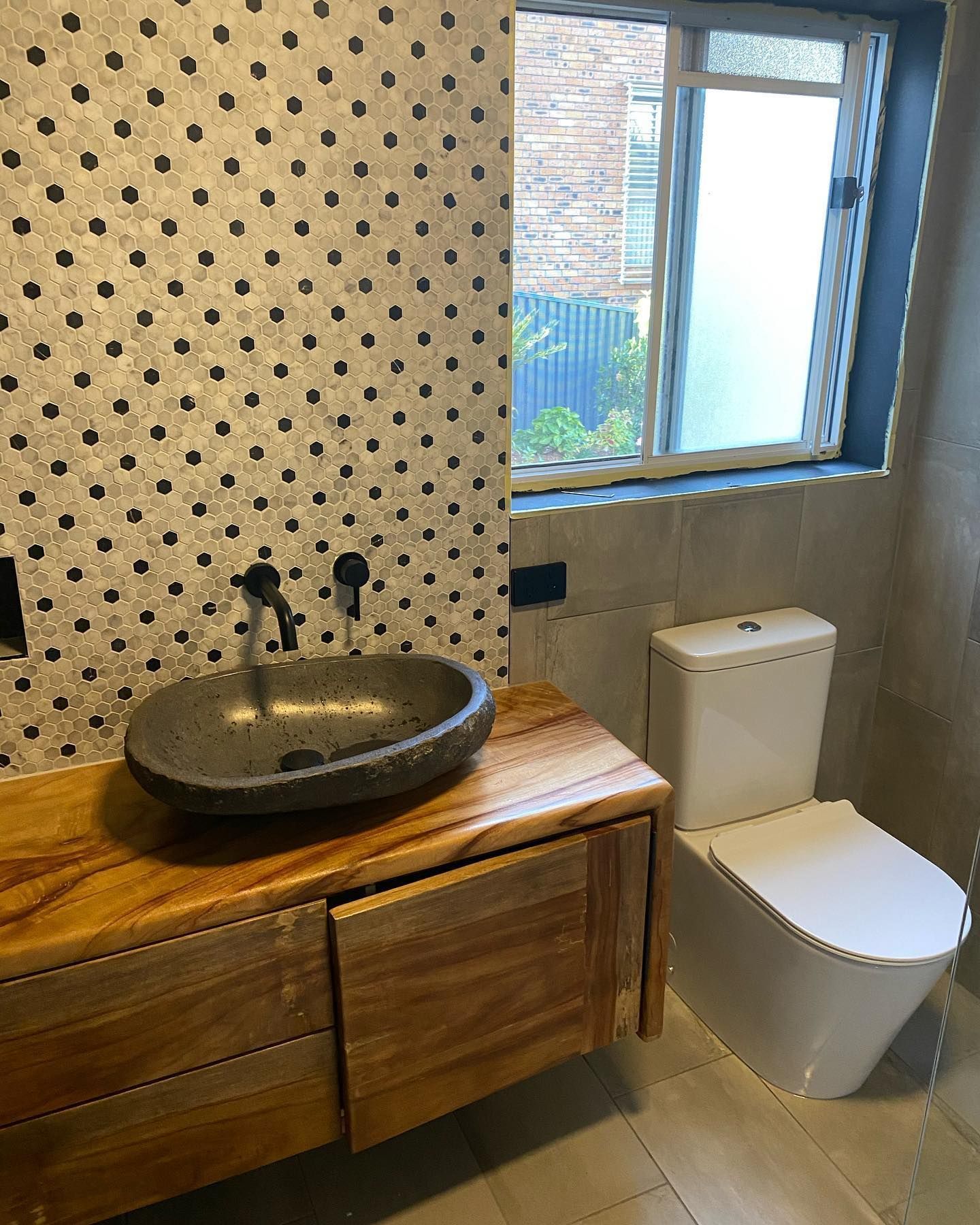 A Bathroom With A Sink , Toilet And Window — Sampson Plumbing Pty Ltd In Casuarina, NSW