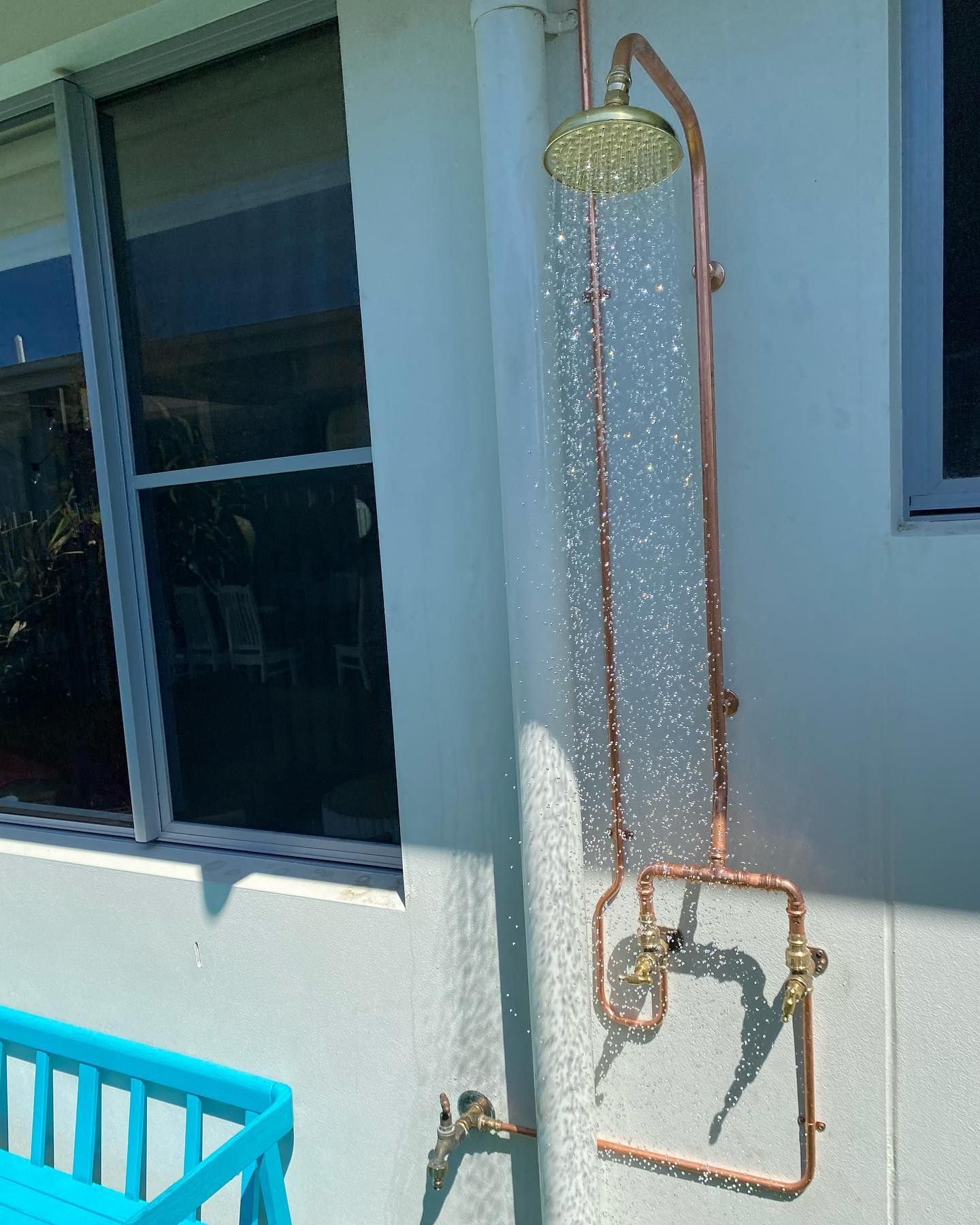 A Copper Outdoor Shower Is Attached To The Side Of A Building — Sampson Plumbing Pty Ltd In Casuarina, NSW