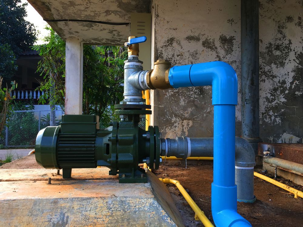 A Green Pump Is Connected To A Blue Pipe — Sampson Plumbing Pty Ltd In Pottsville, NSW
