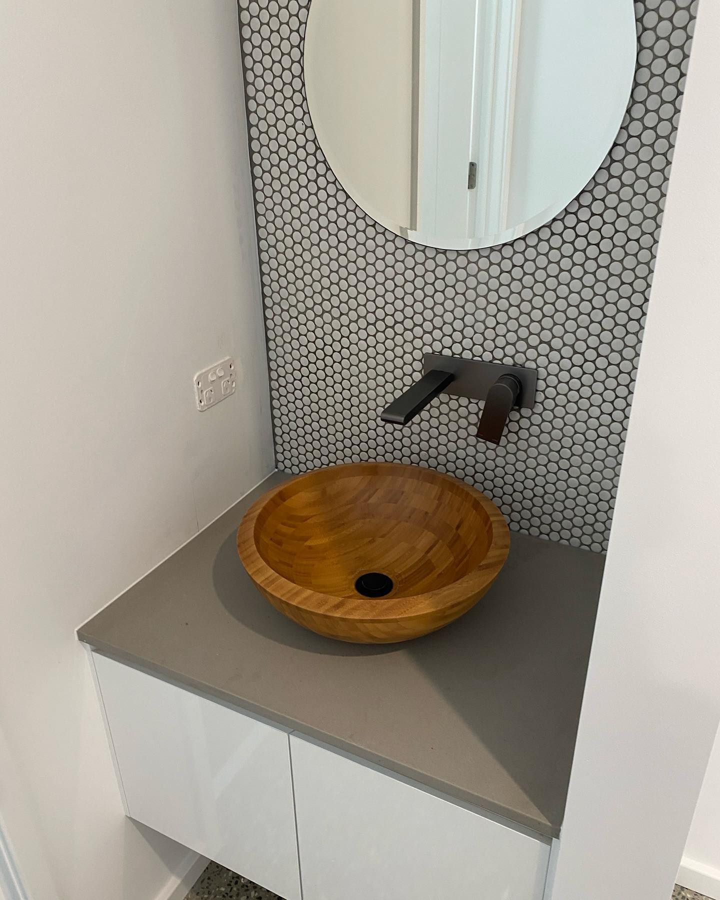 A Bathroom With A Wooden Sink And A Round Mirror — Sampson Plumbing Pty Ltd In Casuarina, NSW