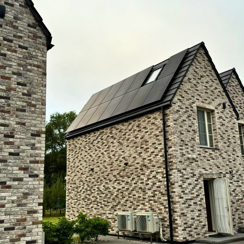 Mūrinis pastatas su saulės baterijomis ant stogo