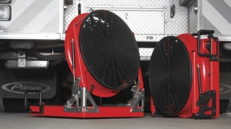 Two red fans are sitting underneath a fire truck
