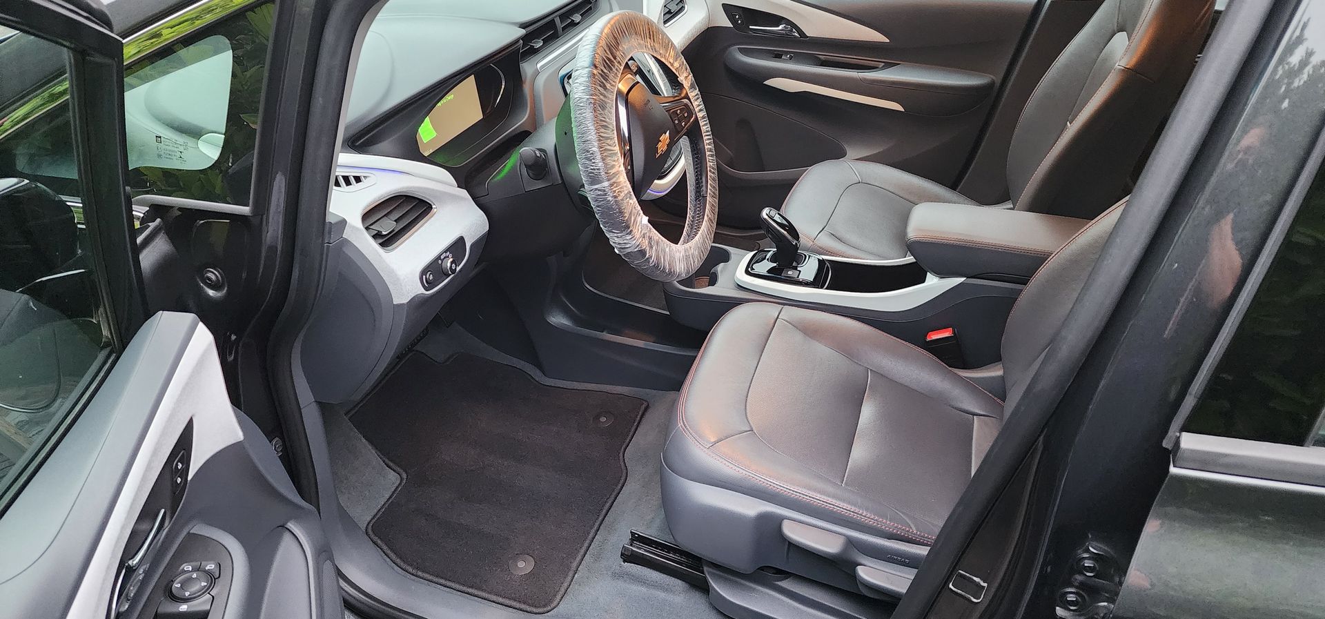 Red leather car interior with center console, dashboard, and panoramic windshield view