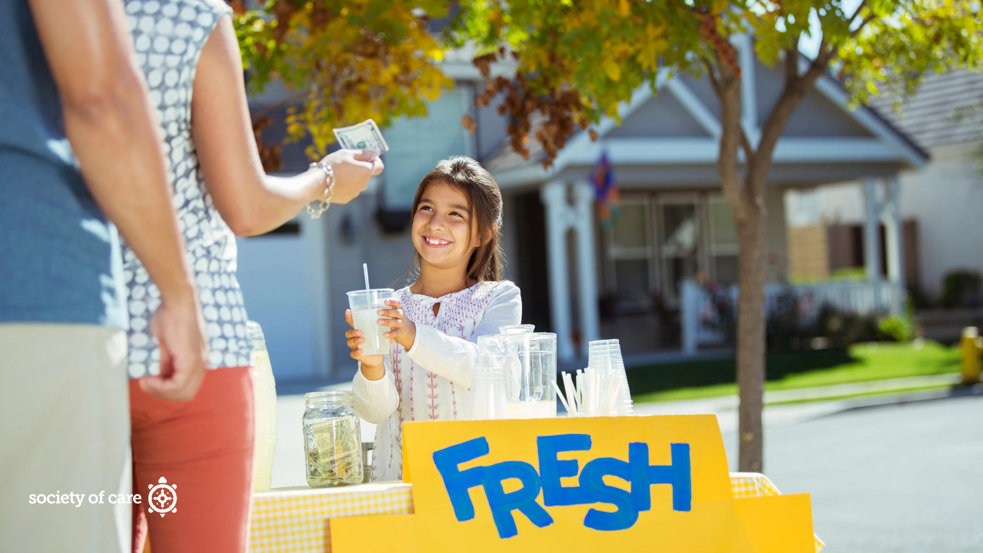 A little girl is selling lemonade from a lemonade stand.