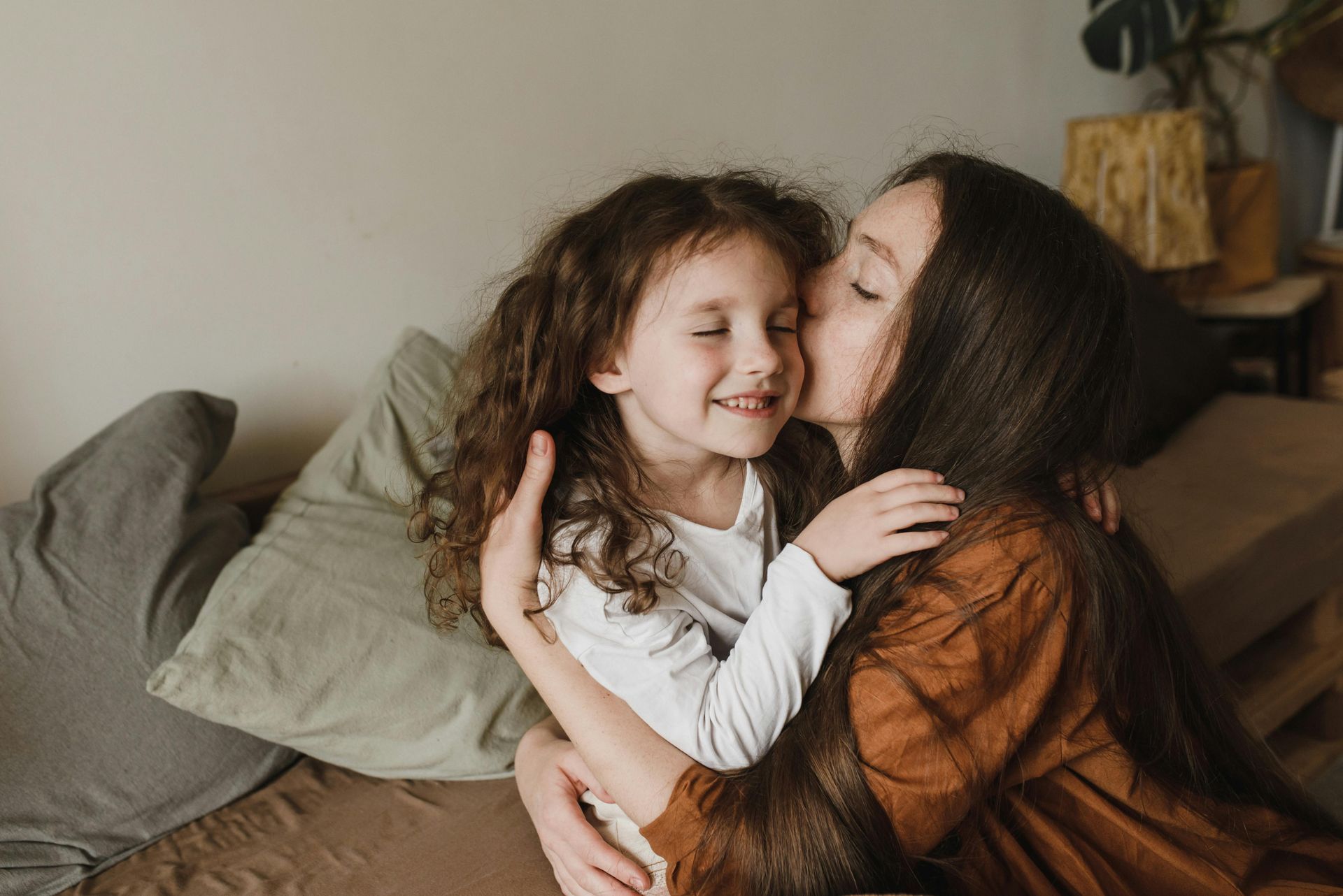 A mother and her daughter hugging and smiling.