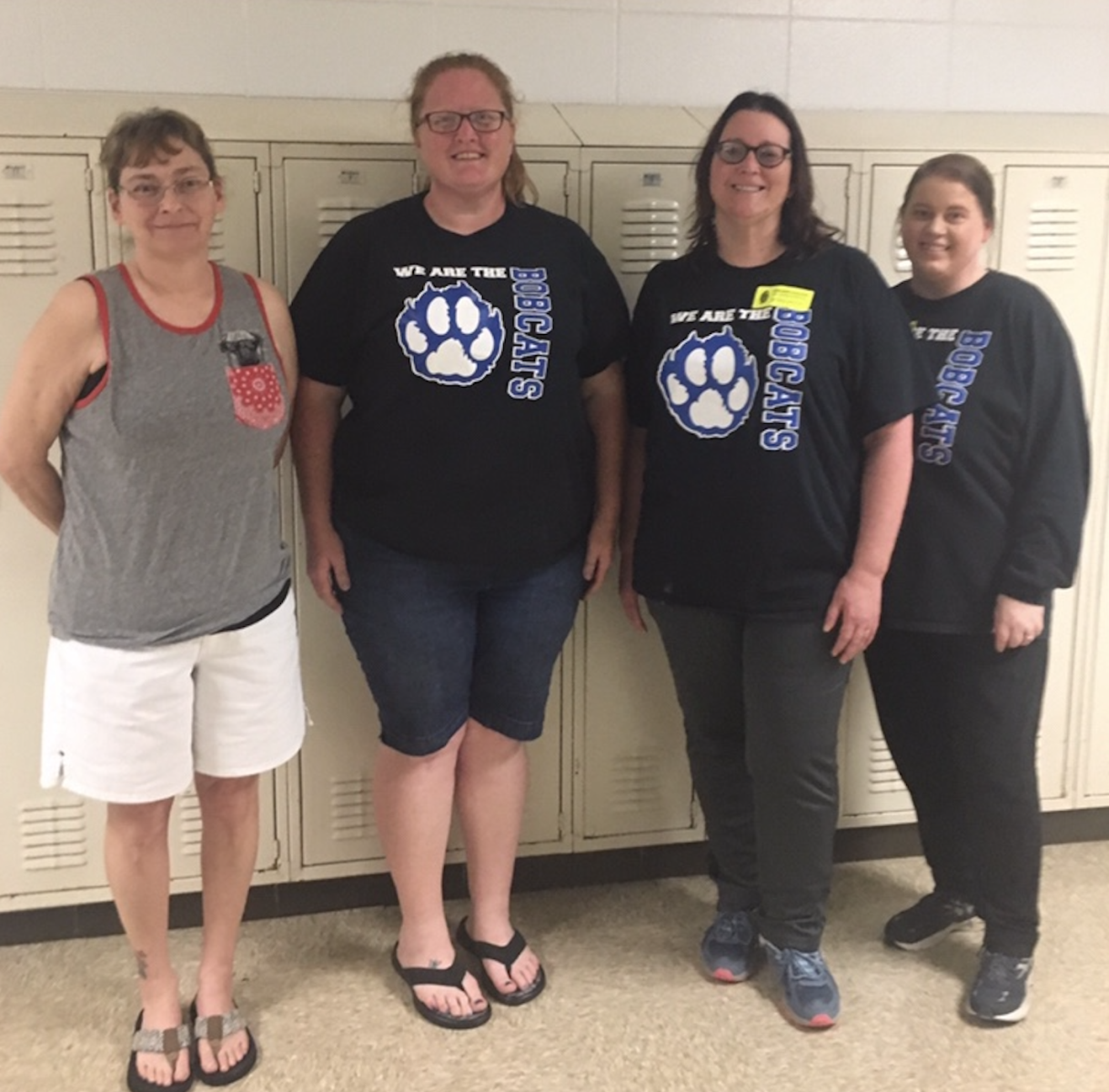 a group of women standing in front of lockers wearing shirts that say blue cats
