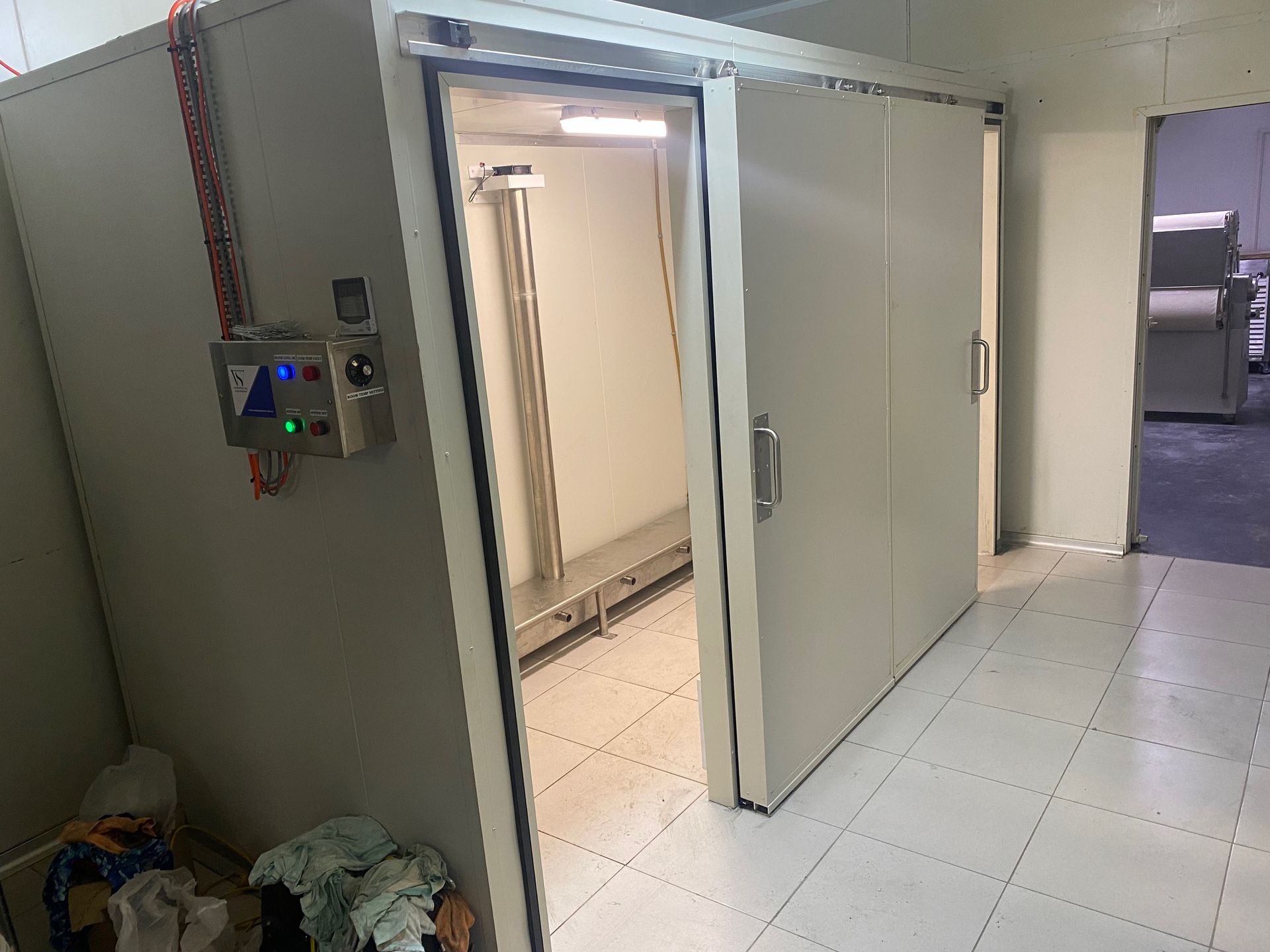 A room with a sliding door and a bunch of trash on the floor.