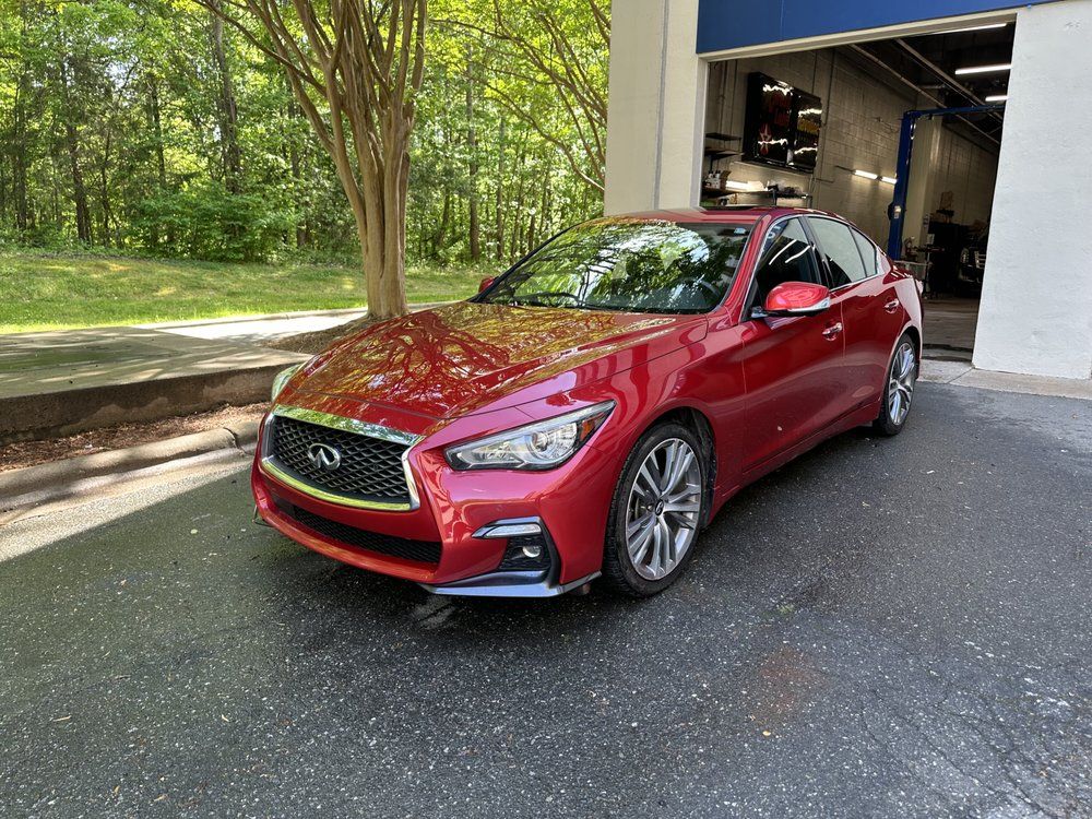 Red Infiniti Q50 Coupe Parked Outside a Garage | Peak Customs and Collision Inc