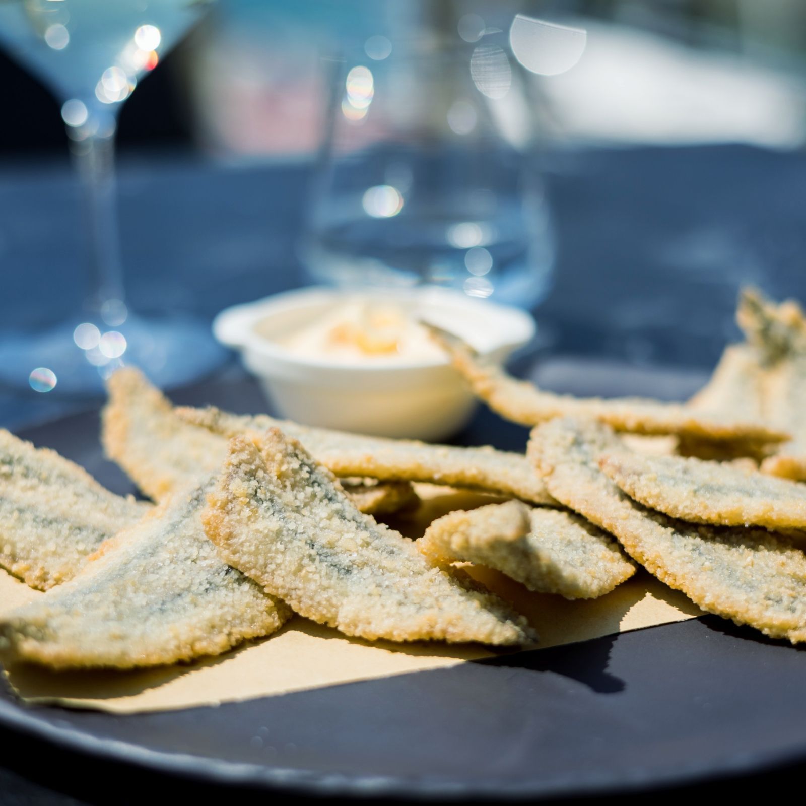 Un piatto di cibo con un bicchiere di vino sullo sfondo