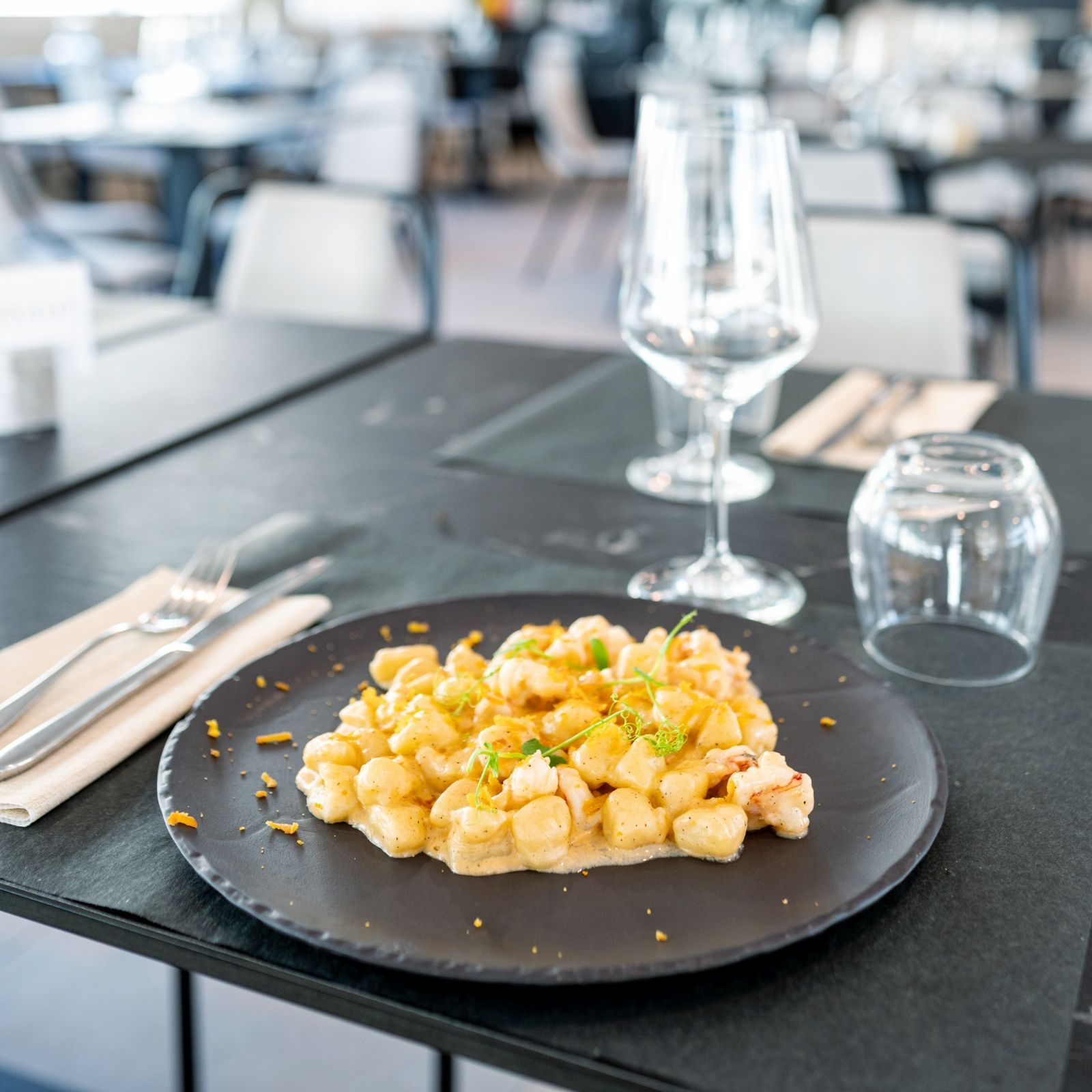 Un piatto di cibo su un tavolo con un bicchiere di vino