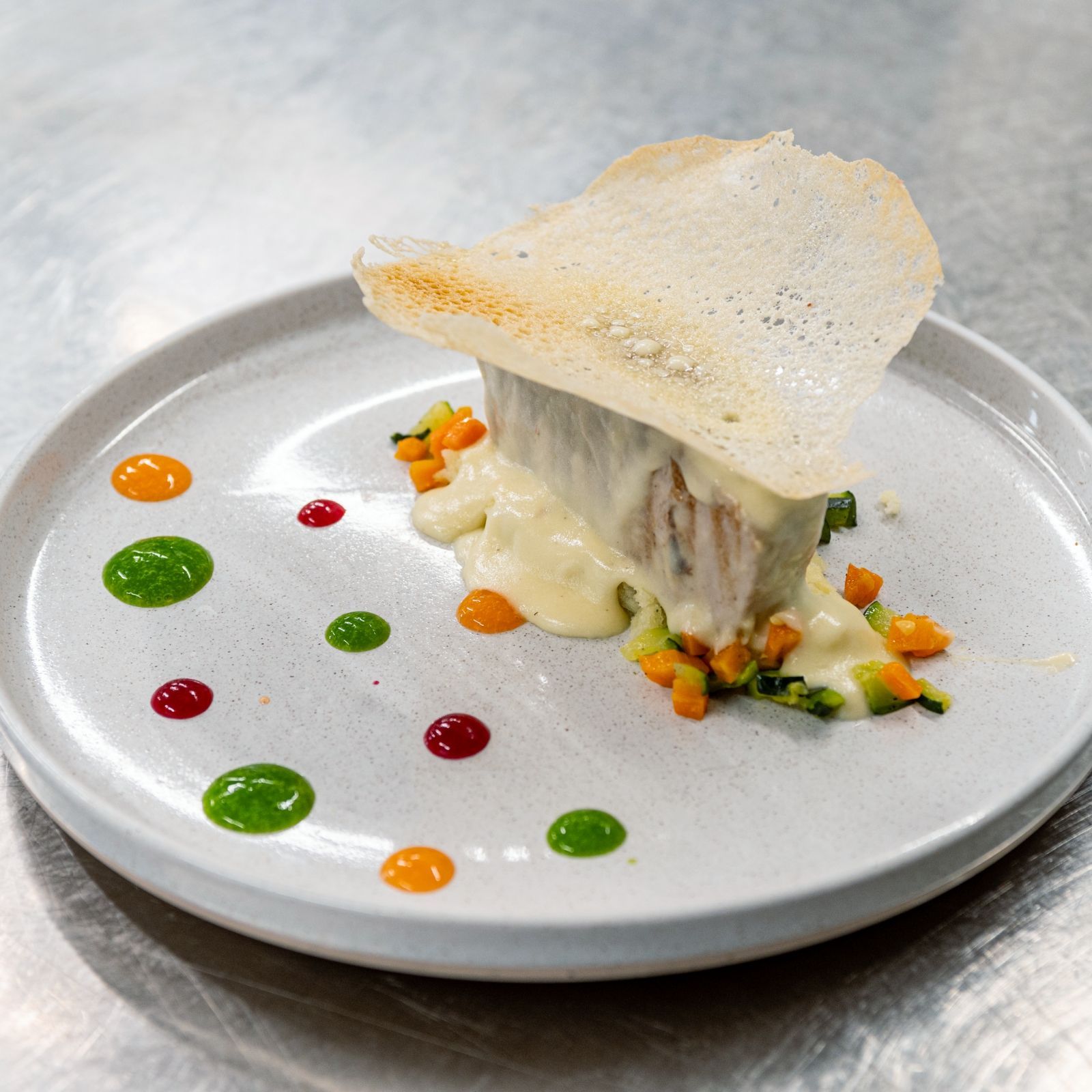 Un piatto bianco sormontato da un pezzo di carne e verdure.