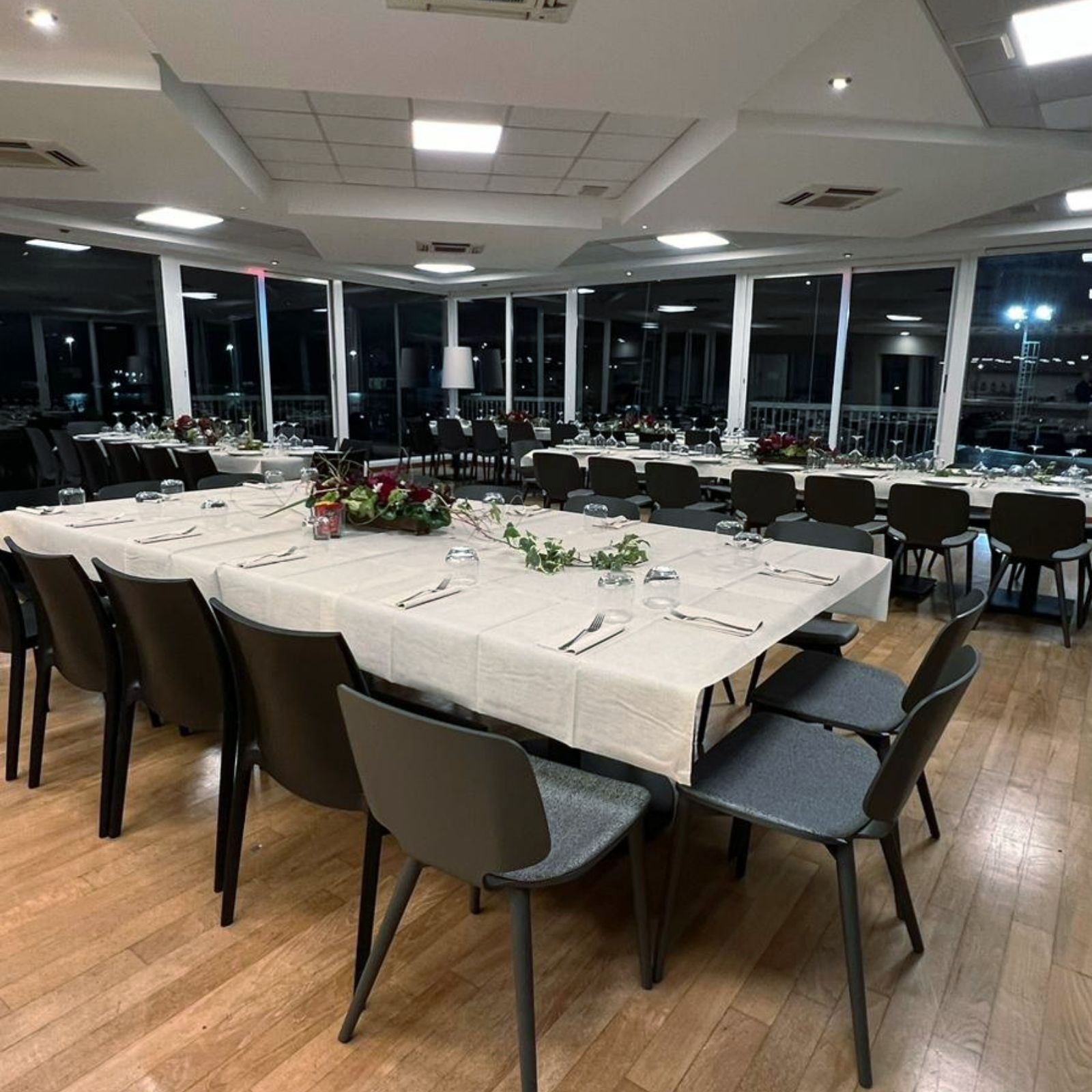 Una grande stanza con tavoli e sedie allestita per una festa