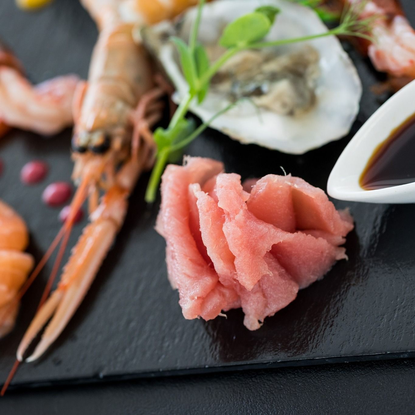 Un primo piano di un piatto di cibo con gamberi e ostriche