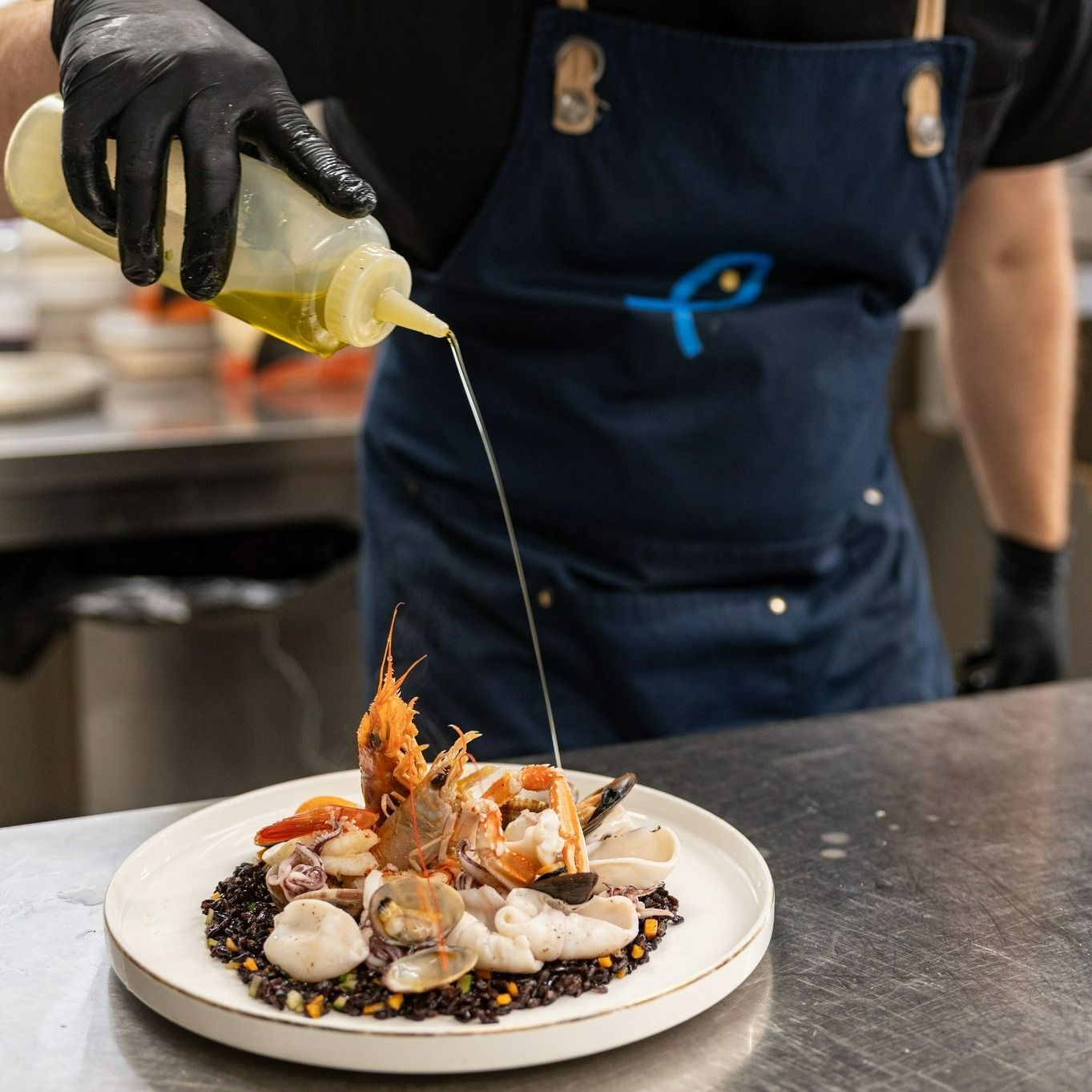 Uno chef sta versando la salsa su un piatto di cibo
