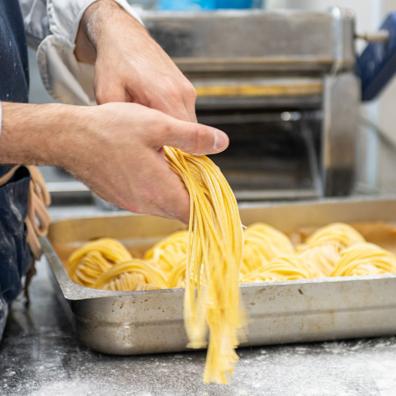 Una persona sta tirando fuori gli spaghetti dalla padella.