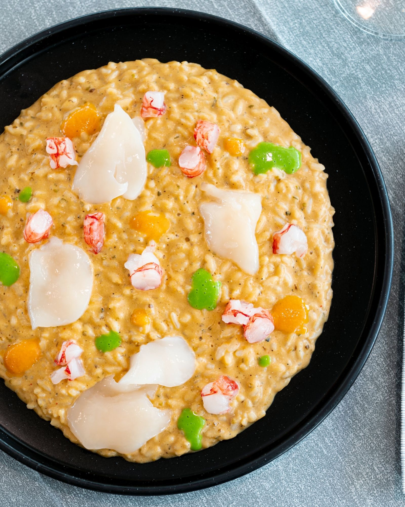Primo piano di un piatto di cibo con gamberi e verdure su un tavolo.