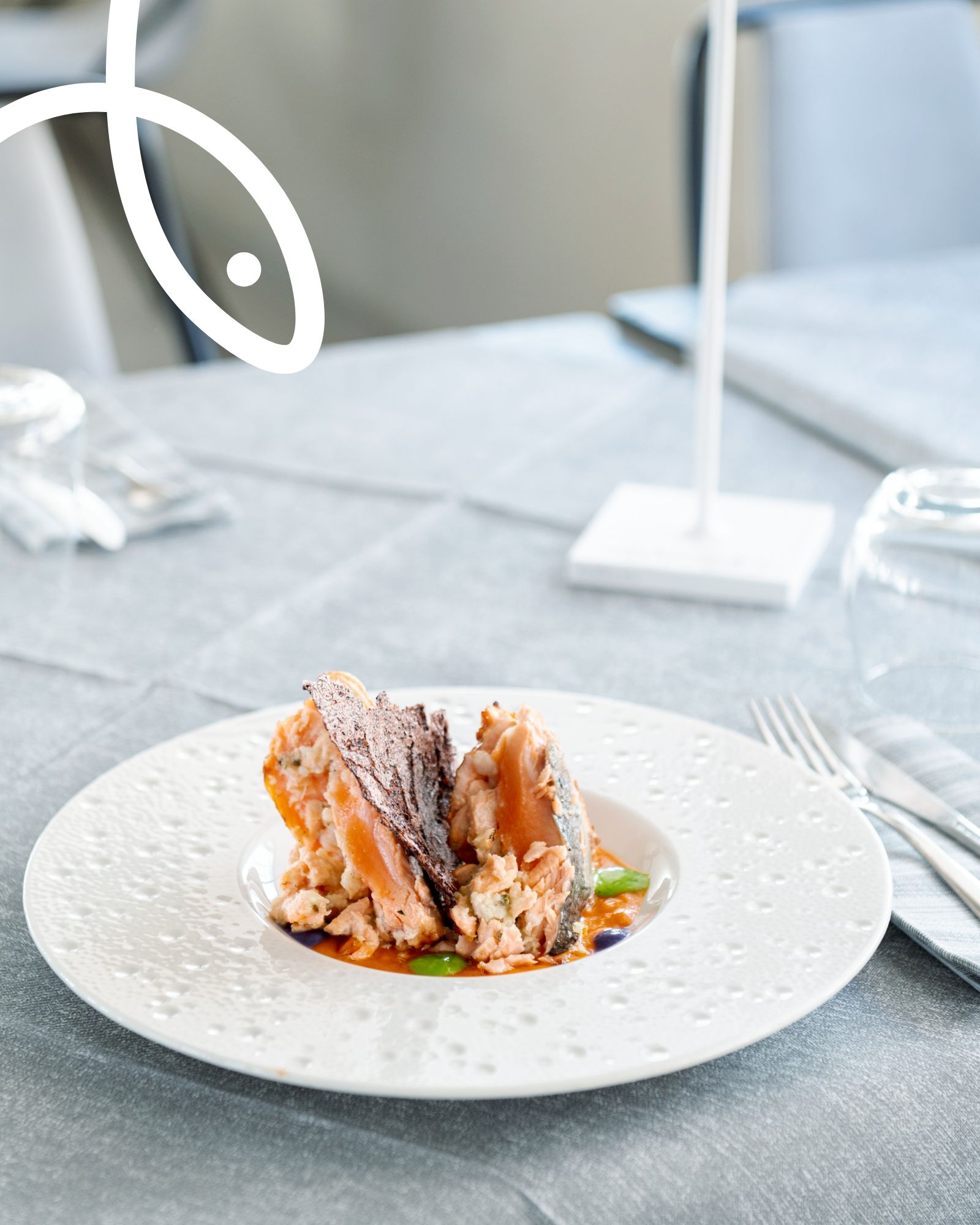 Un piatto di cibo su un tavolo con un pesce sullo sfondo