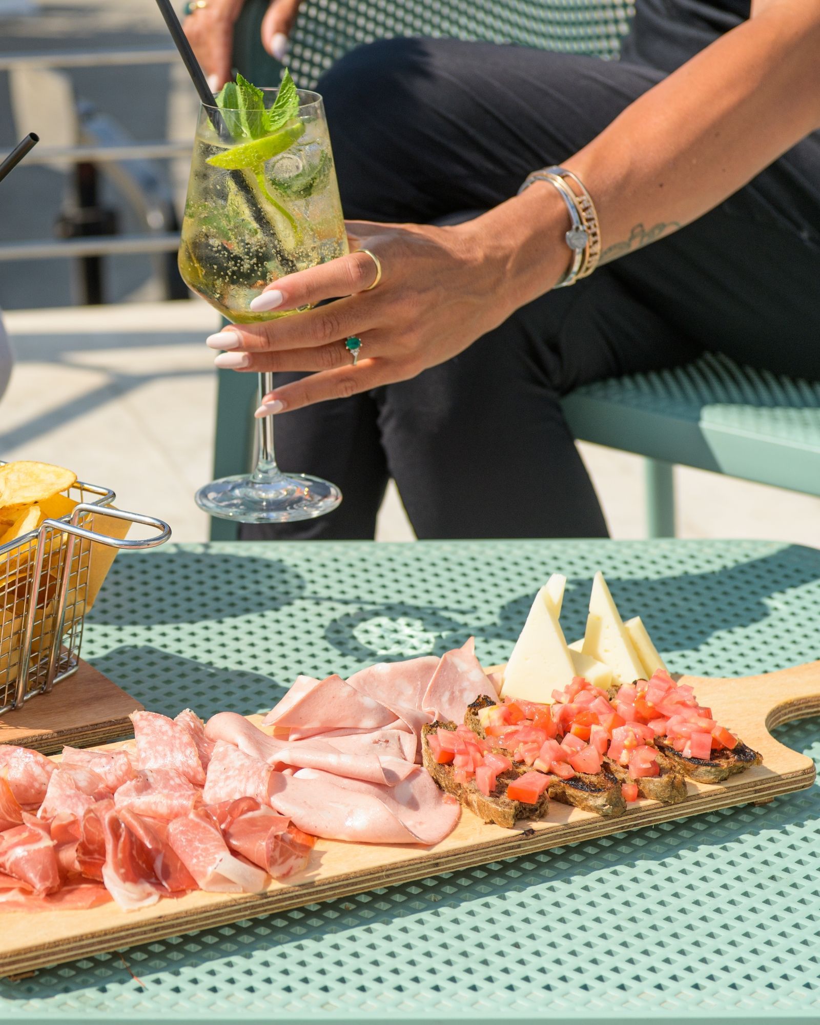 Una donna è seduta a un tavolo con un piatto di cibo e un bicchiere di vino.