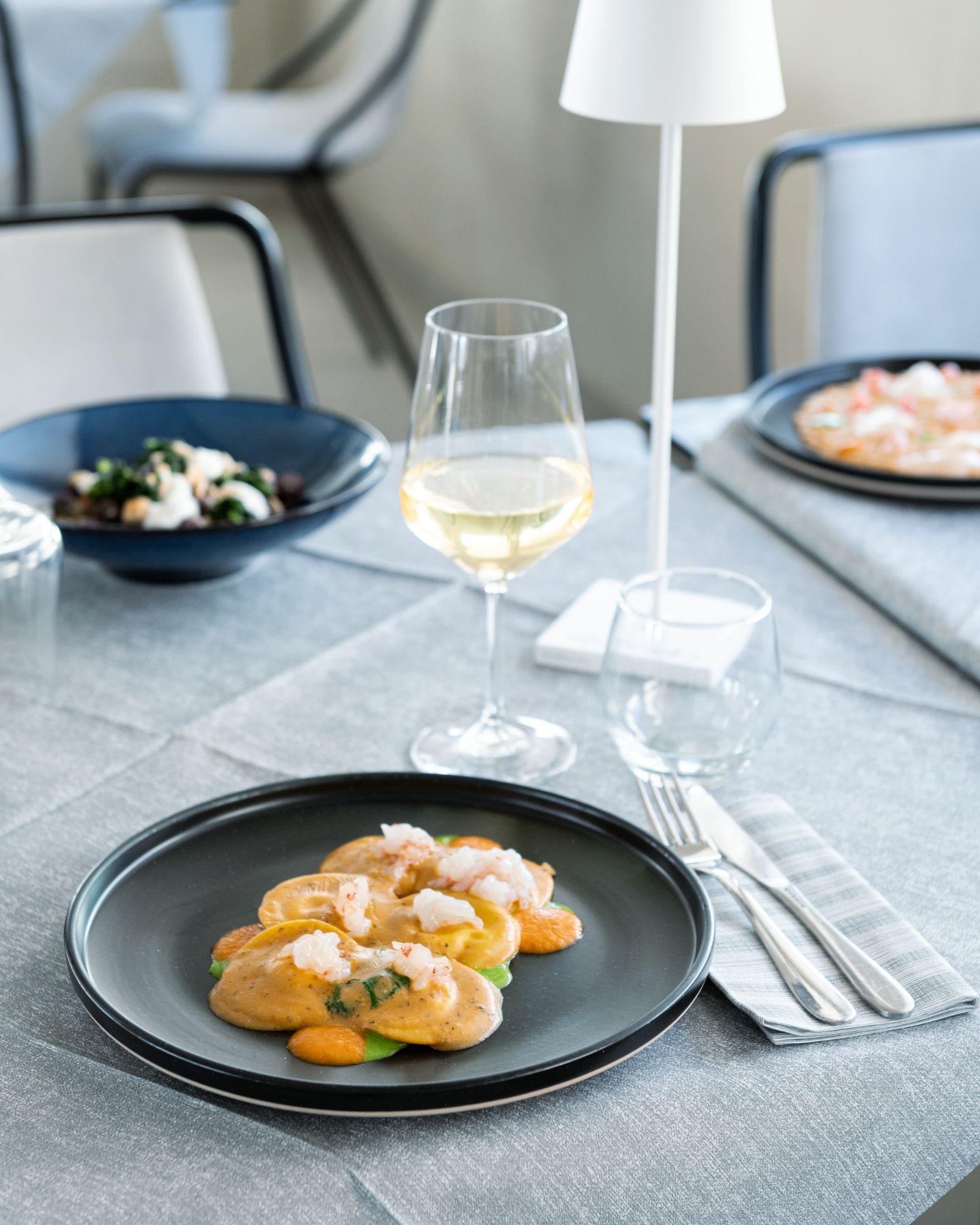 Un piatto di cibo e un bicchiere di vino su un tavolo.