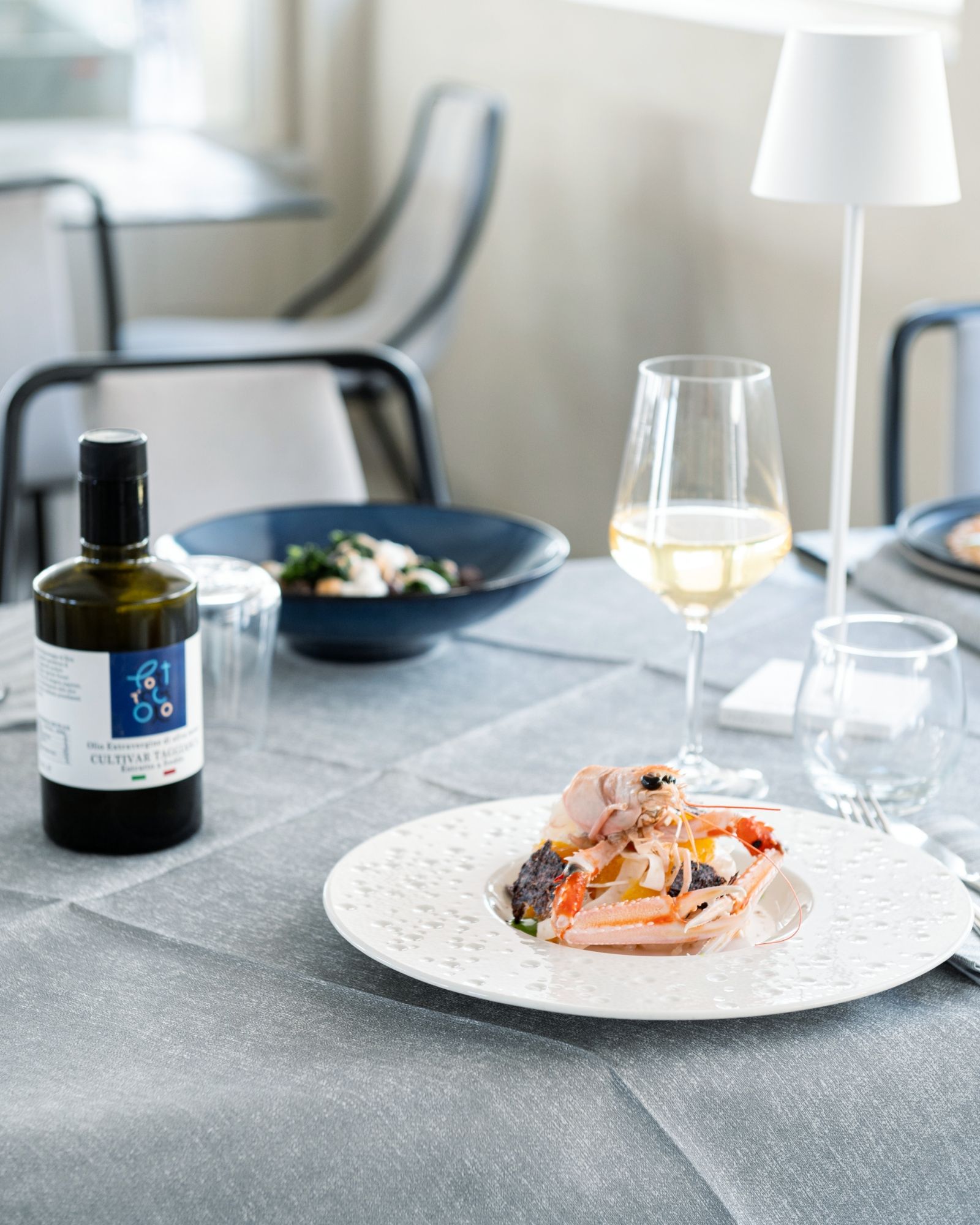 Un piatto di cibo e un bicchiere di vino su un tavolo.