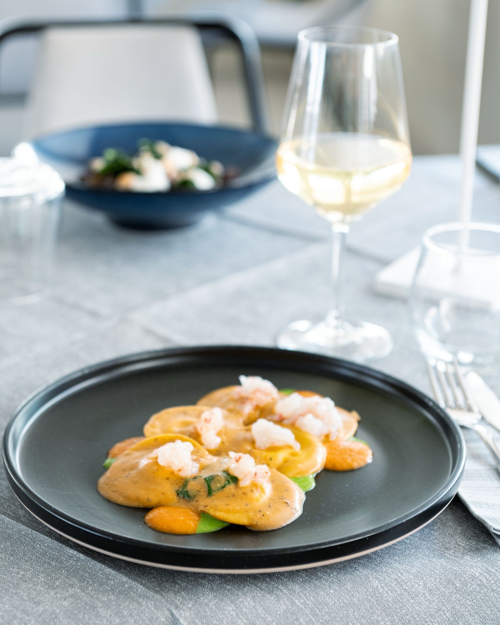 Un piatto di cibo e un bicchiere di vino su un tavolo.