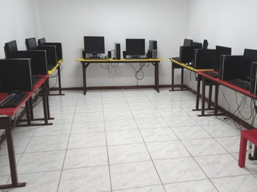 Uma sala com muitos computadores em mesas