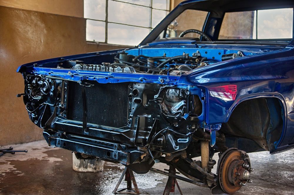 A Blue Car with The Engine Removed Is Sitting on A Stand in A Garage  — Bakers Creek Wreckers In Yeppoon, QLD