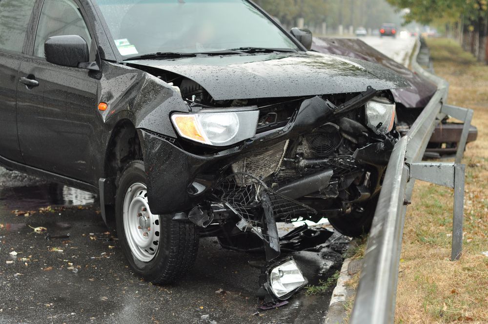 A Black Car With A Damaged Front End Is Parked On The Side Of The Road — Bakers Creek Wreckers In Yeppoon, QLD