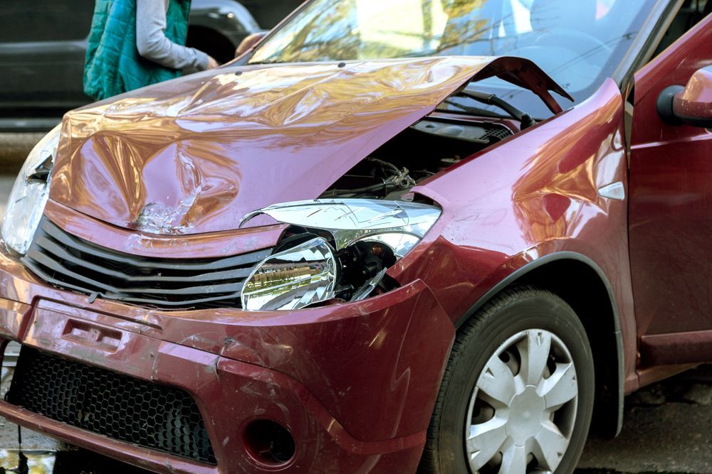 A Woman Is Standing Next To A Red Car With Its Hood Up — Bakers Creek Wreckers In Bakers Creek, QLD