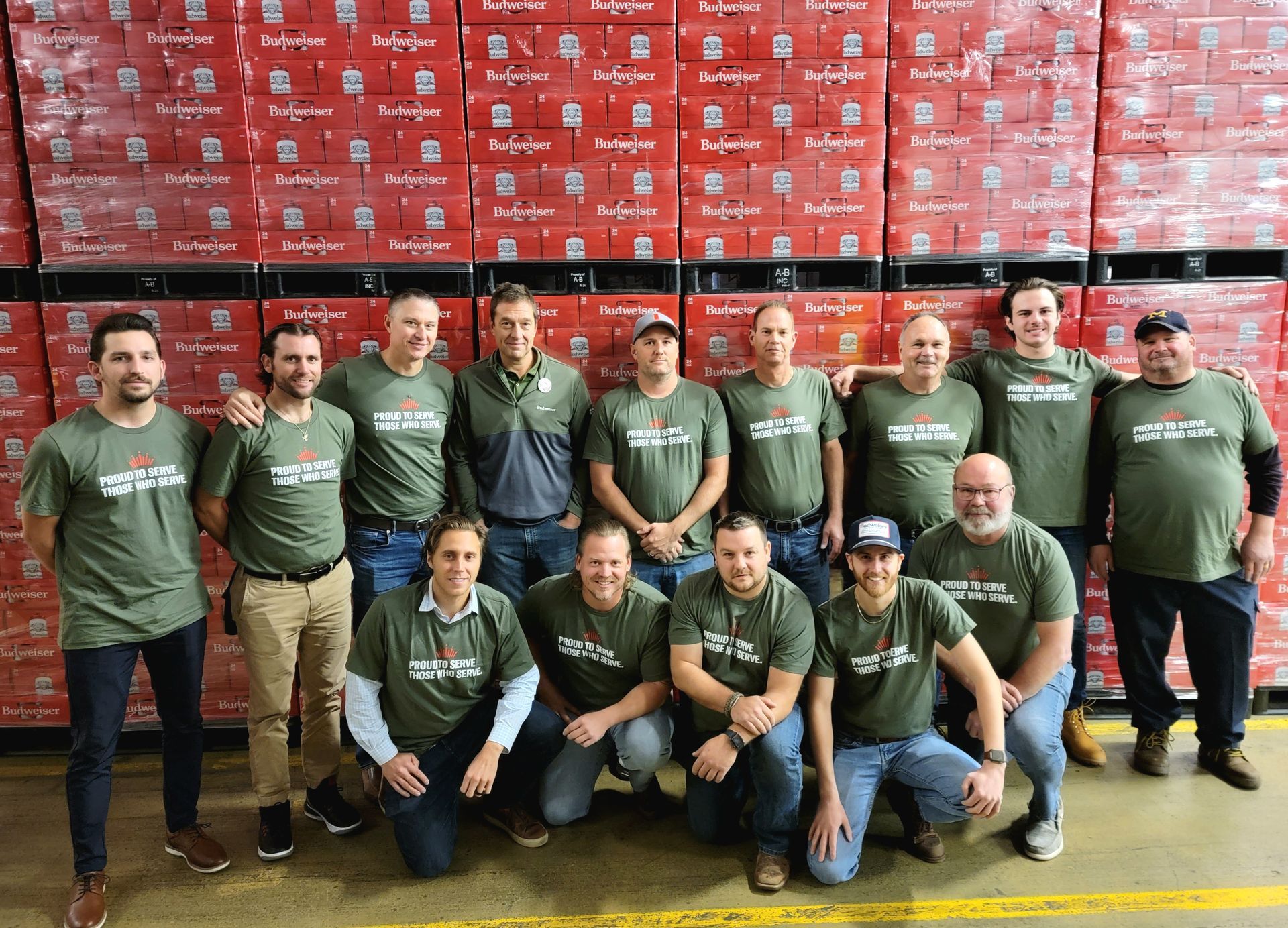A group of men are posing for a picture in a warehouse.