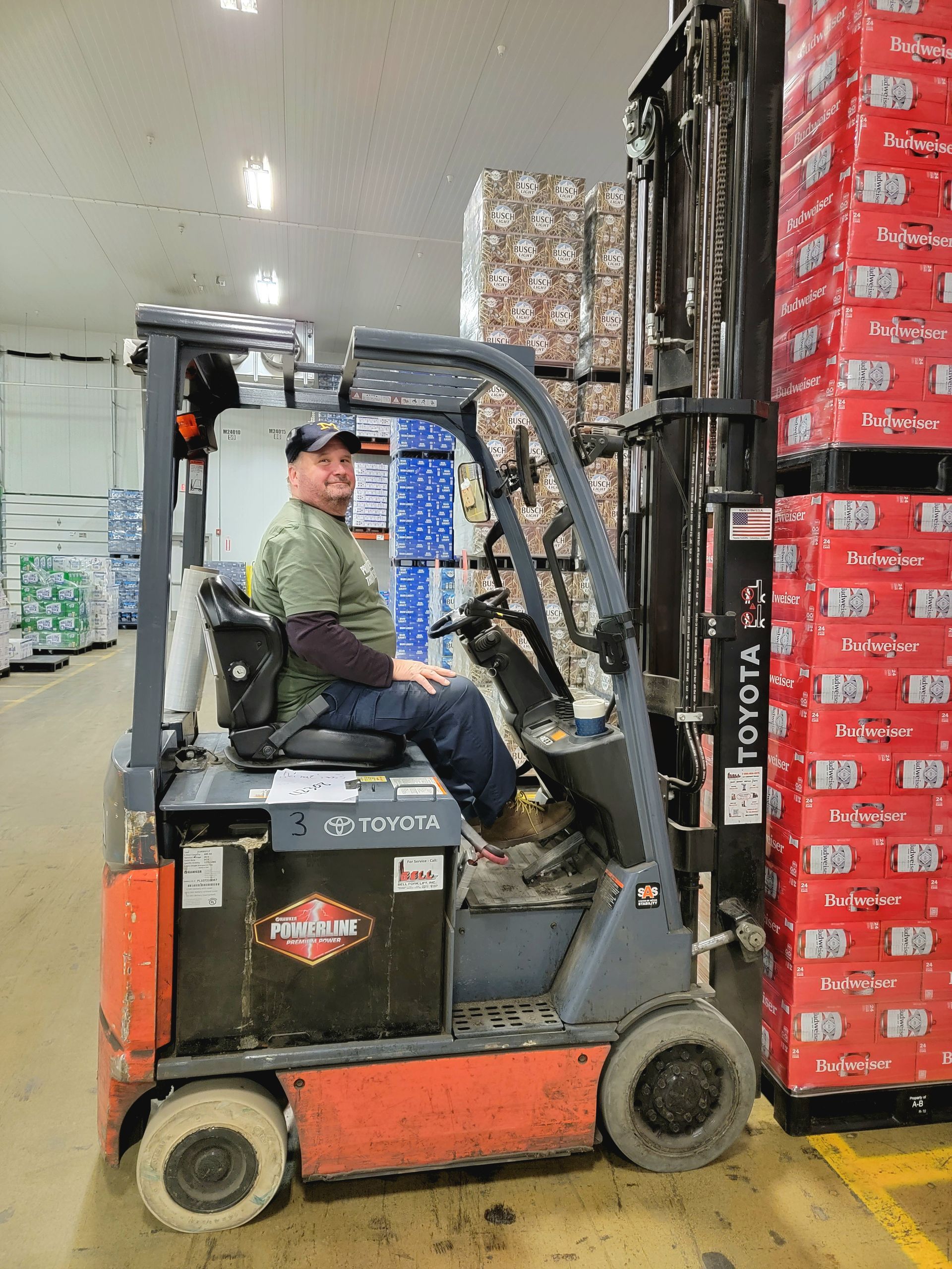 A man is driving a forklift in a warehouse.