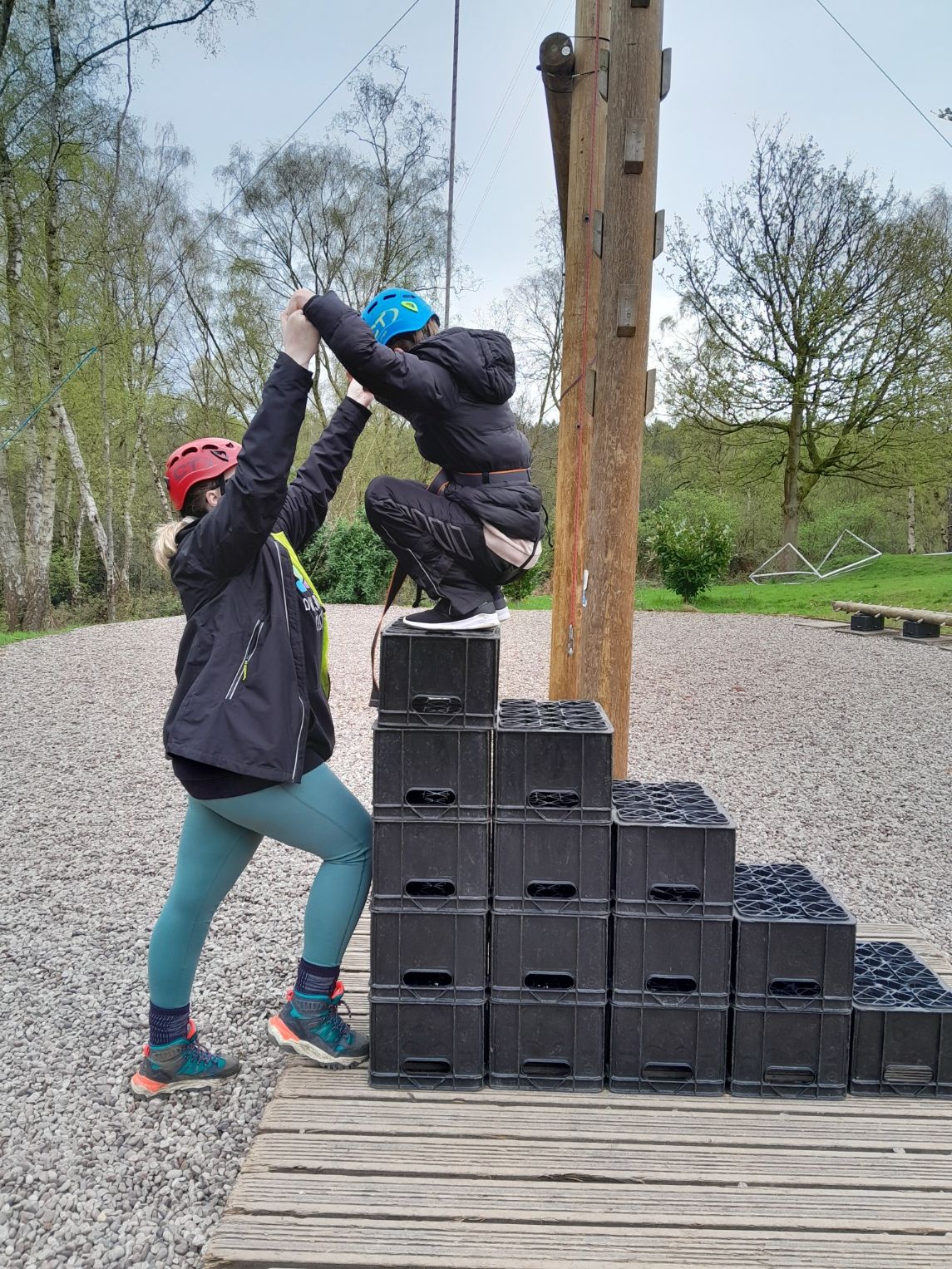 young person with Down syndrome jumping off plastic stacking crates with the some help 