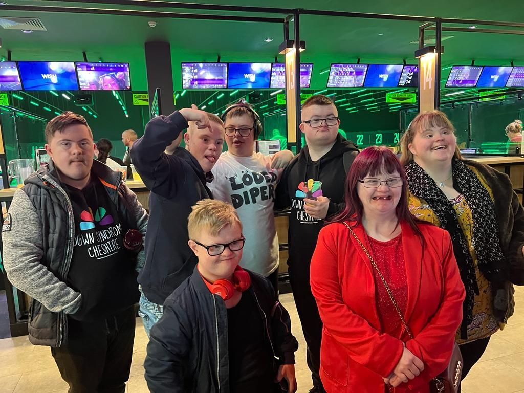 a group of people are posing for a picture in a bowling alley .