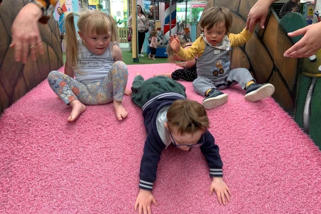 a group of children are playing on a pink carpet .
