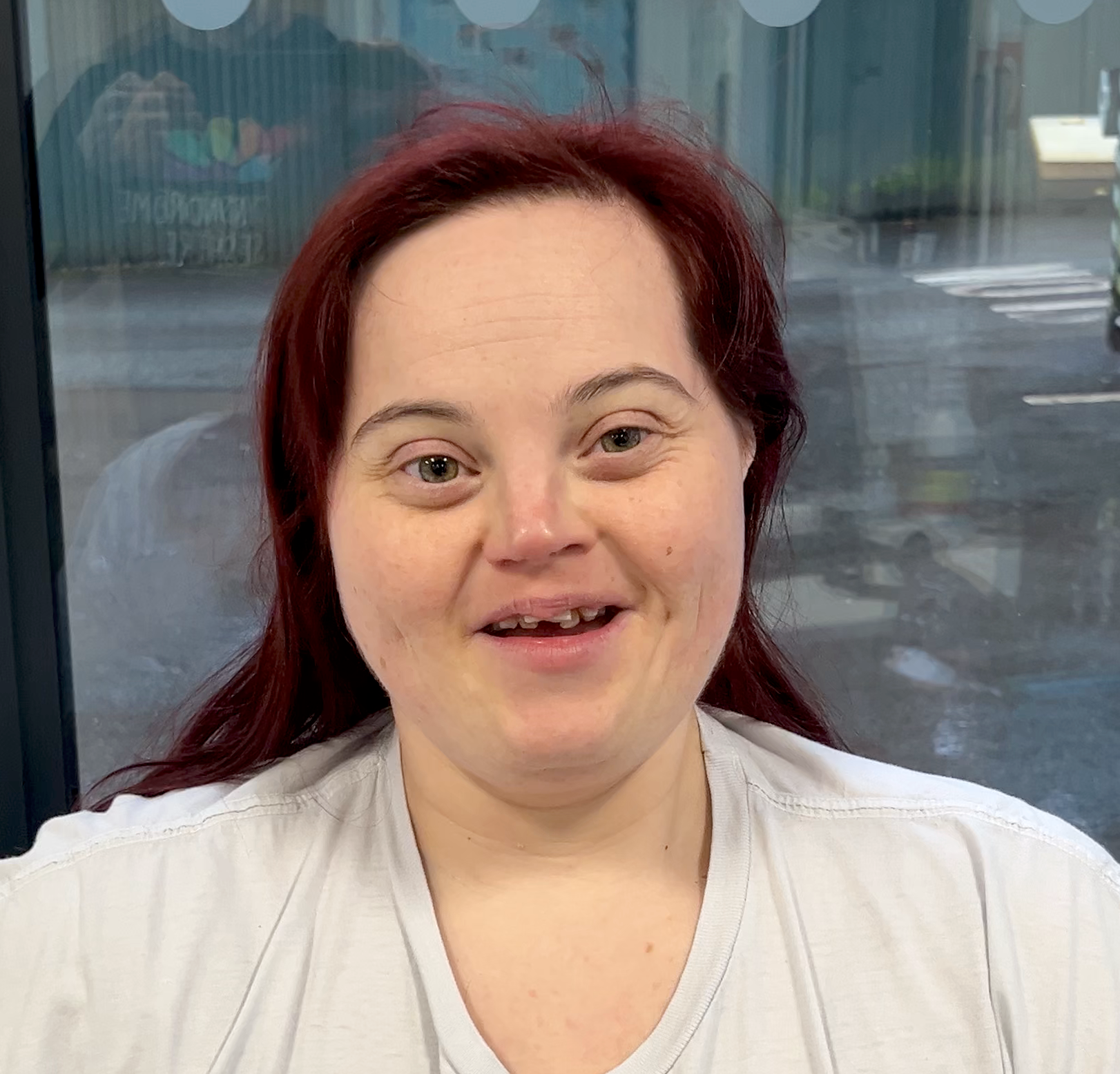 a woman in a black hoodie is smiling for the camera .