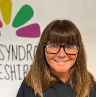 a woman wearing a black hoodie is smiling for the camera .