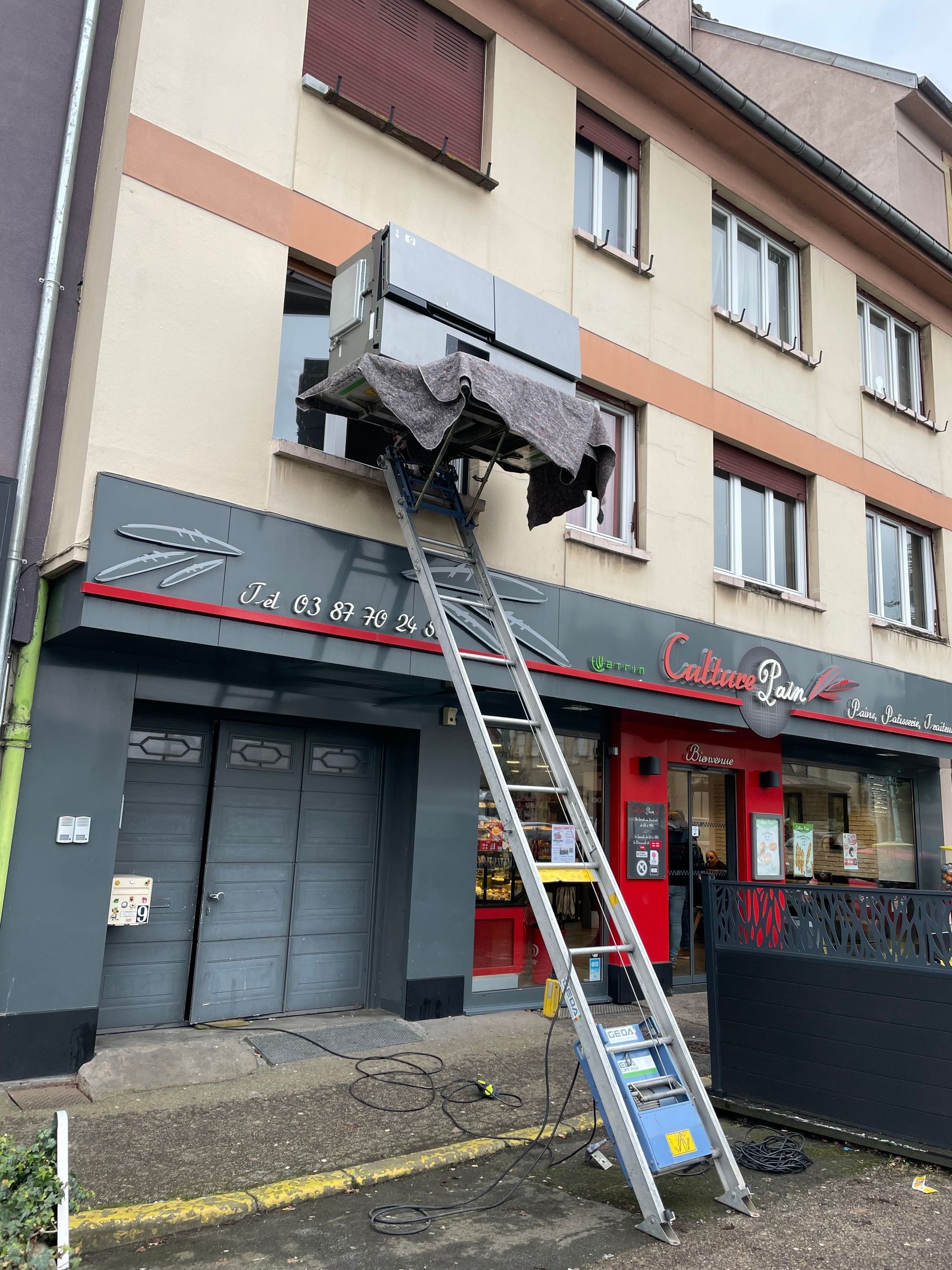 Une échelle est assise devant un bâtiment.