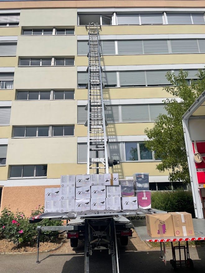 Un camion avec des caisses à l'arrière est garé devant un bâtiment.