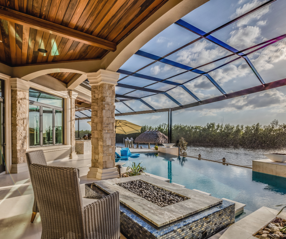 Outdoor patio with pool, fire pit, lake view, wood ceiling, stone columns.