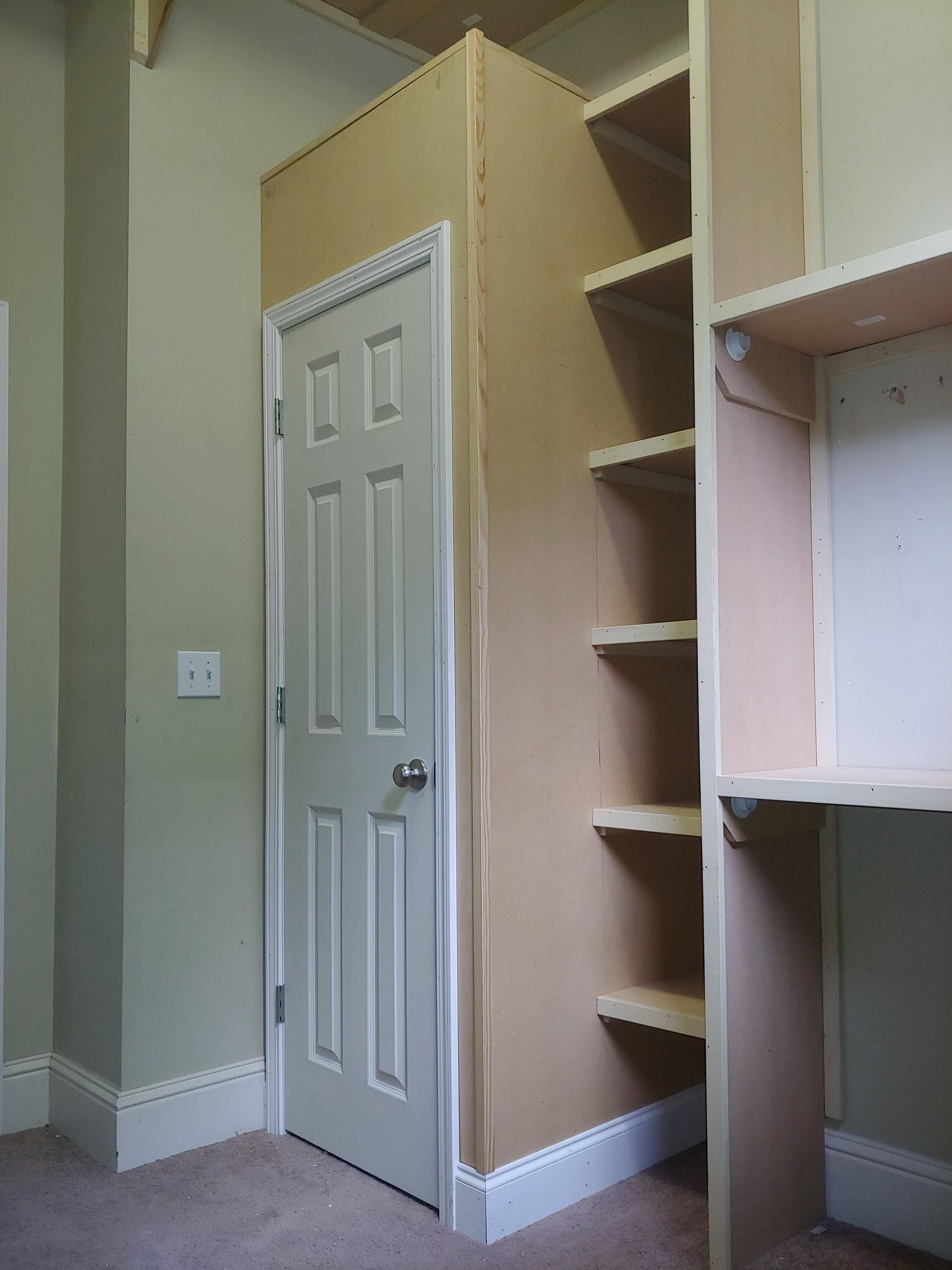 A room with a door and shelves in it